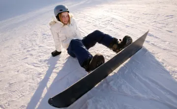 photo of young teen snowboarder sitting in the snow