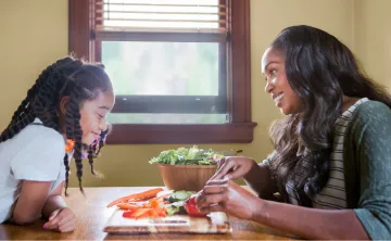 image of mom making a healthy salad with young daughter