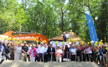 A large group of elected officials and metrowest residents pose at the construction site.