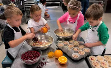 kids preparing cranberry and orange muffins in the MetroWest YMCA kitchen